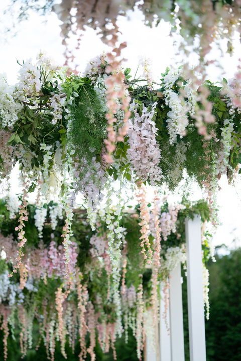 an outdoor wedding with flowers hanging from the ceiling