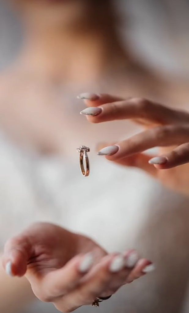 a woman is holding out her hand with a ring on it