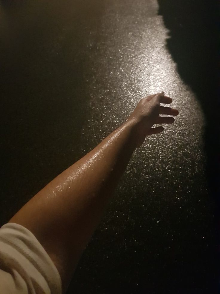 a person's arm and hand on a wet surface