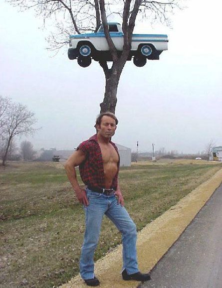 a man standing next to a tree with a truck on it