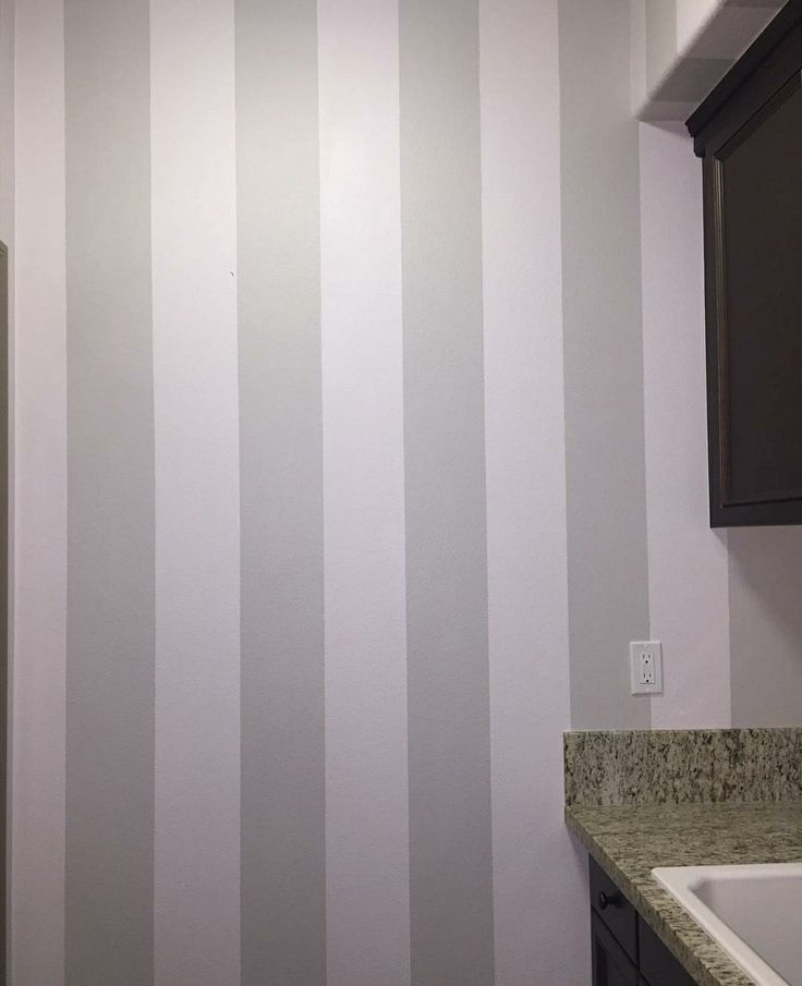 a bathroom with white and grey striped walls