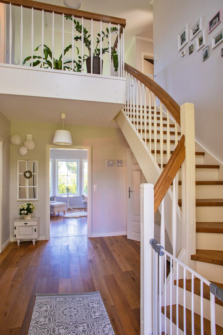 an open floor plan with wood floors and white railings