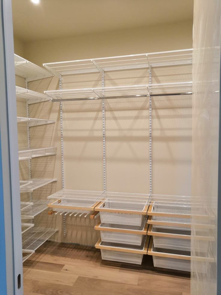 an empty walk in closet with shelves and bins