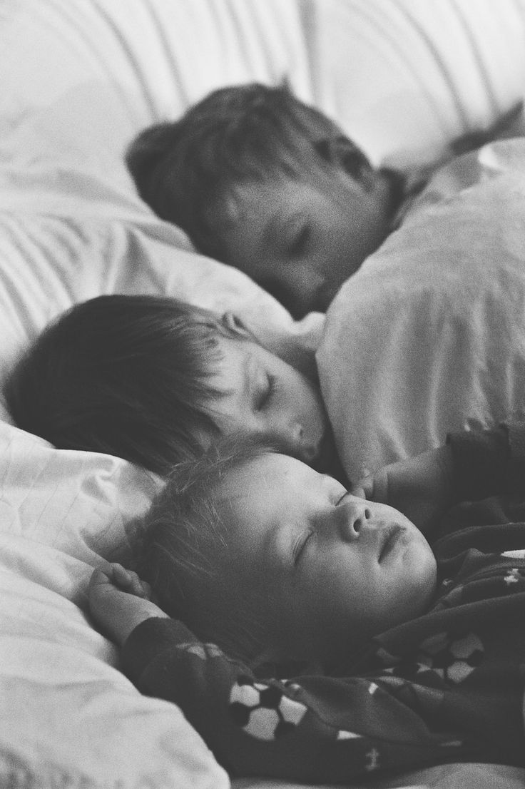 two young children sleeping on a bed next to each other