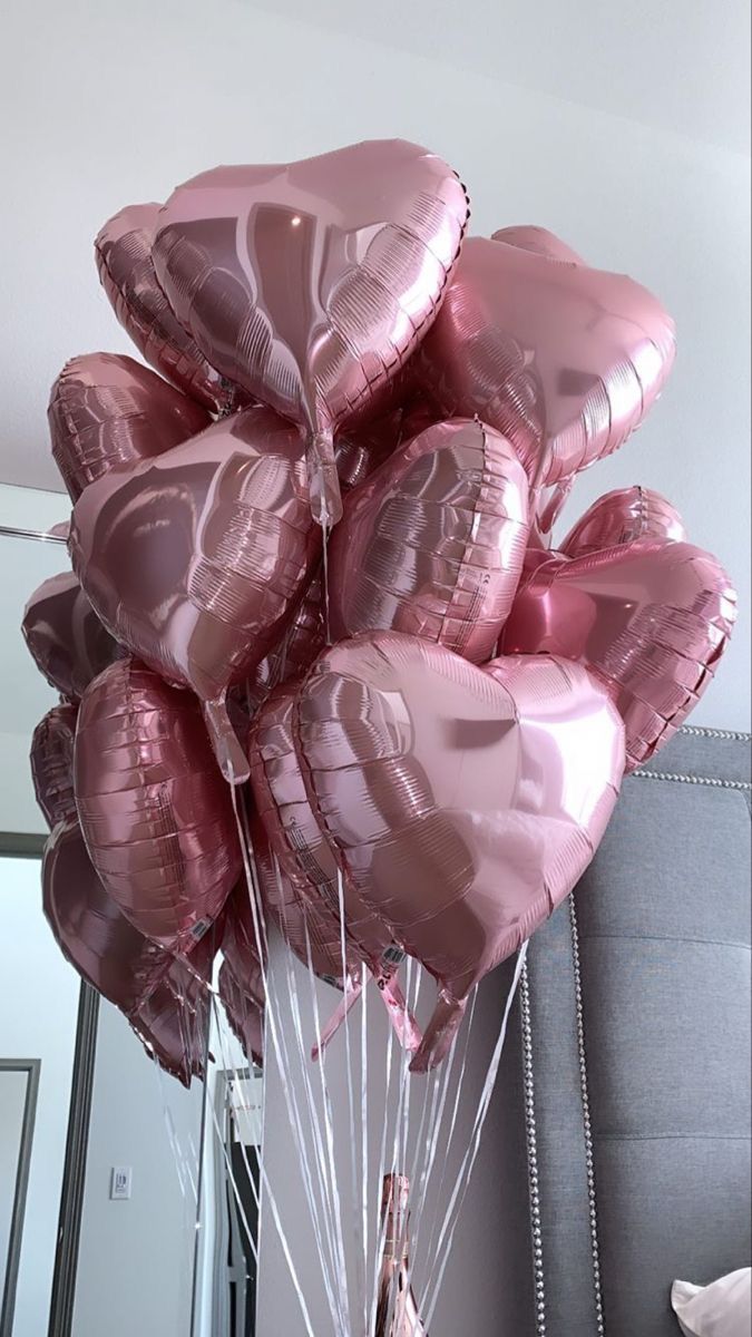 a bunch of pink heart shaped balloons in a vase