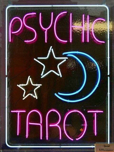 a neon sign that says psychic tarot with stars and crescent on it's side