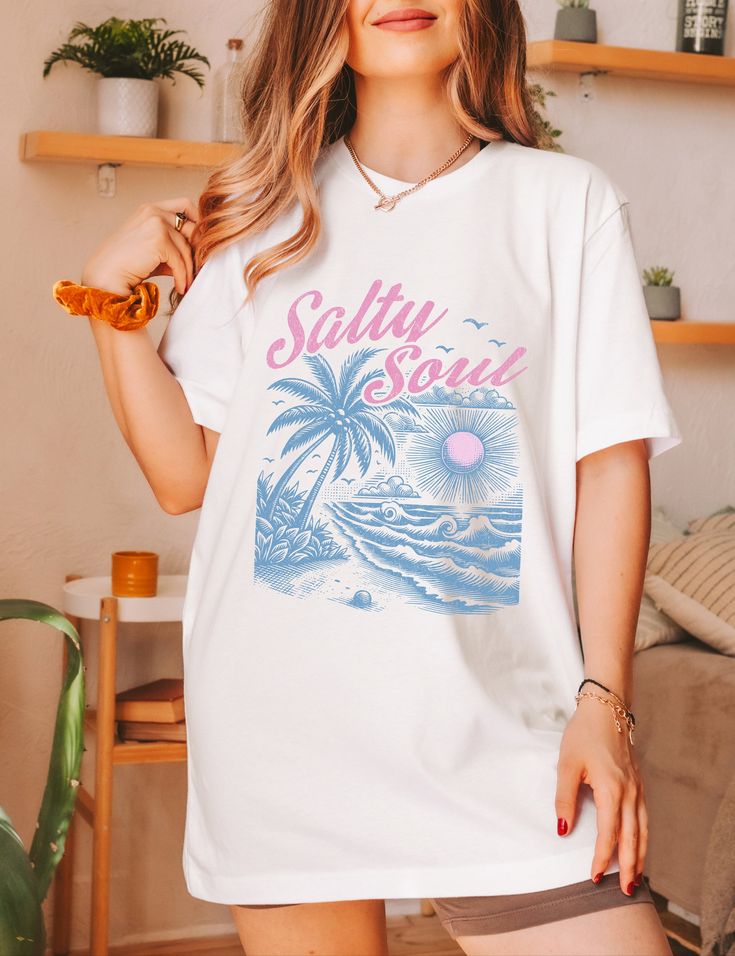 Elevate your beach vibes with our Salty Soul Shirt! This beachy shirt is perfect for any beach bum looking to embrace those ocean inspired vibes. Made for those who live for the summer time, this Salty Beach Shirt exudes a laid-back charm that captures the essence of the sea. Add a touch of coastal cool to your wardrobe with this must-have addition to your collection of beachy shirts! ✧ ABOUT OUR PRODUCTS ✧ For a oversized fit, go up two sizes.- Unisex fit, true to size.- Check the size chart be Casual Beach Shirt With Palm Tree Print, Short Sleeve Shirt For Beach Vacation, Short Sleeve Printed Shirt For Beach, Blue Beach T-shirt With Front Print, Summer Cotton T-shirt With Palm Tree Print, Relaxed Fit Palm Tree Print Shirt For Beach, Relaxed Fit Shirt With Palm Tree Print For Beach, Summer Shirt With Tropical Print For Vacation, White Beach Shirt For Summer