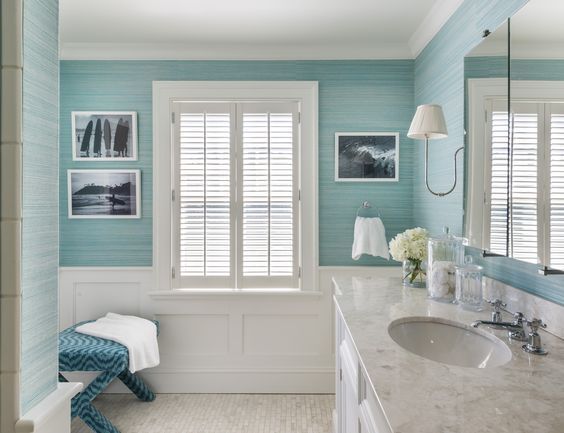 a bathroom with blue walls and pictures on the wall