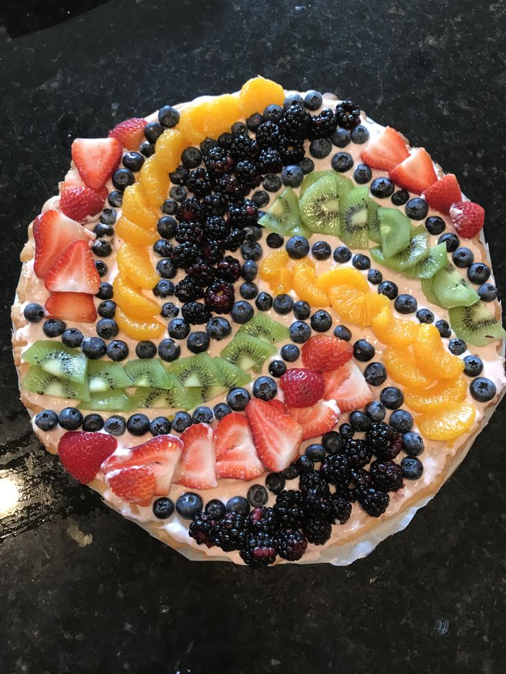 a cake with fruit on it sitting on top of a table