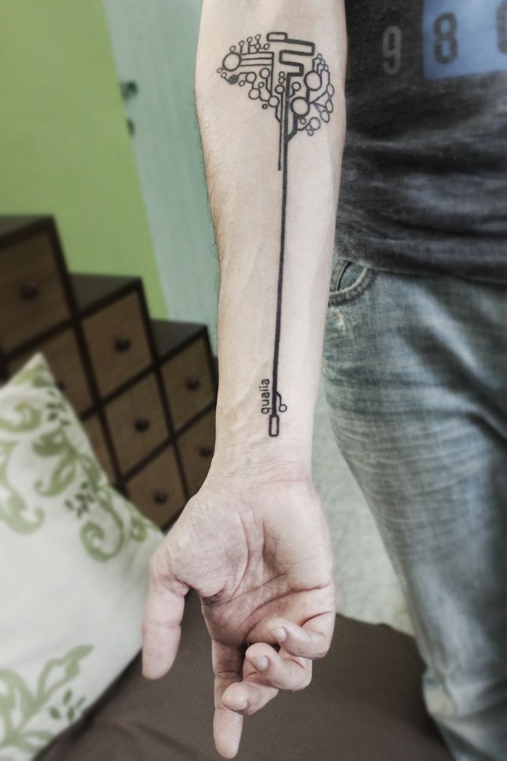 a person with a tattoo on their arm pointing to the left side of his arm