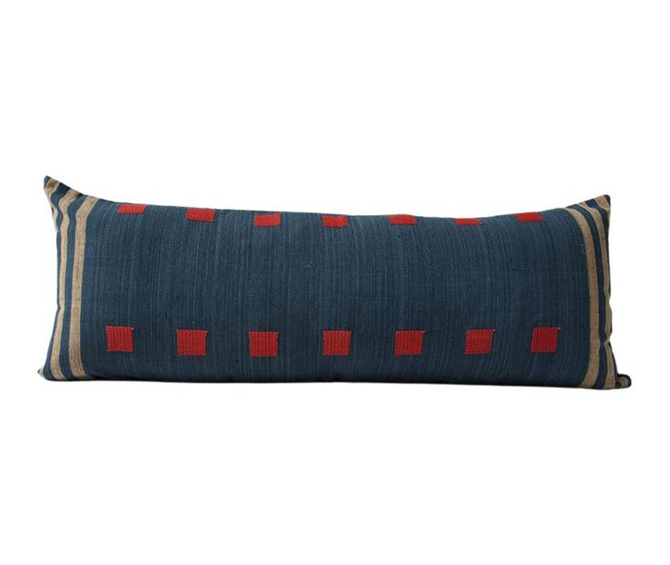 a blue pillow with red squares on the front and back, sitting against a white background