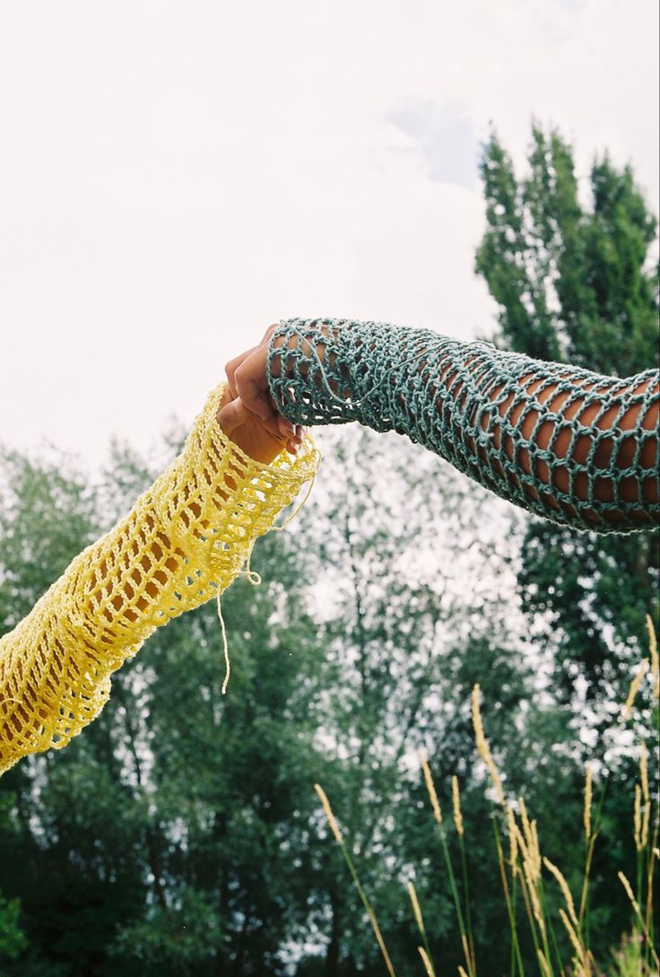 a person holding something in their hand with trees in the backgrouds behind them