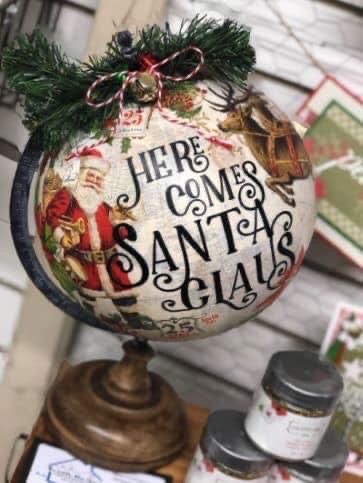 a christmas ornament on top of a table with other holiday items around it