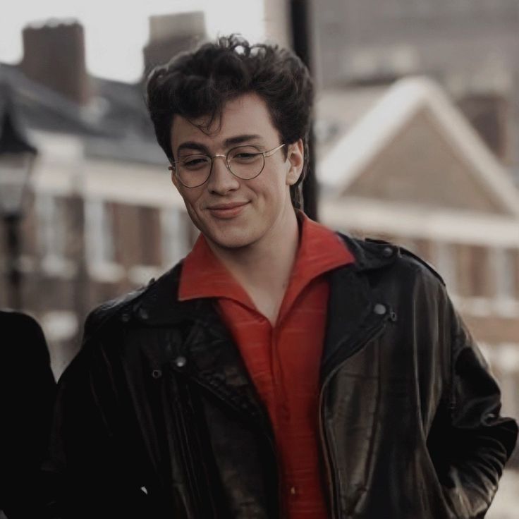 a young man wearing glasses and a red shirt