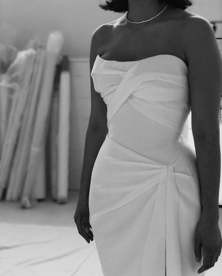 a woman in a white dress posing for the camera