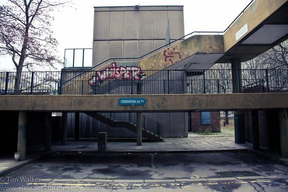 an abandoned building with graffiti on the wall and stairs leading up to it's second floor