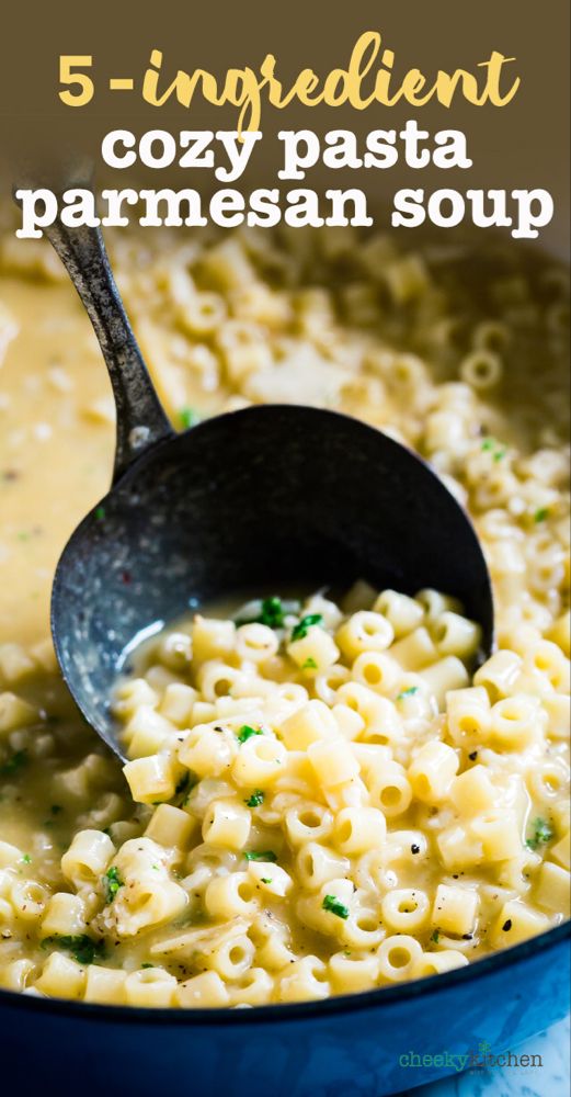 a pot filled with pasta and sauce on top of a blue tablecloth next to a wooden spoon