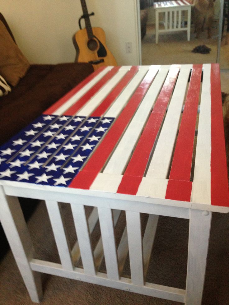 an american flag made out of pallet wood sitting on the floor next to a guitar