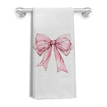 a white towel with a pink bow hanging from it's side on a hook