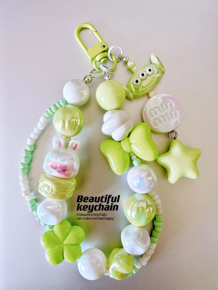 a green and white bracelet with charms on it