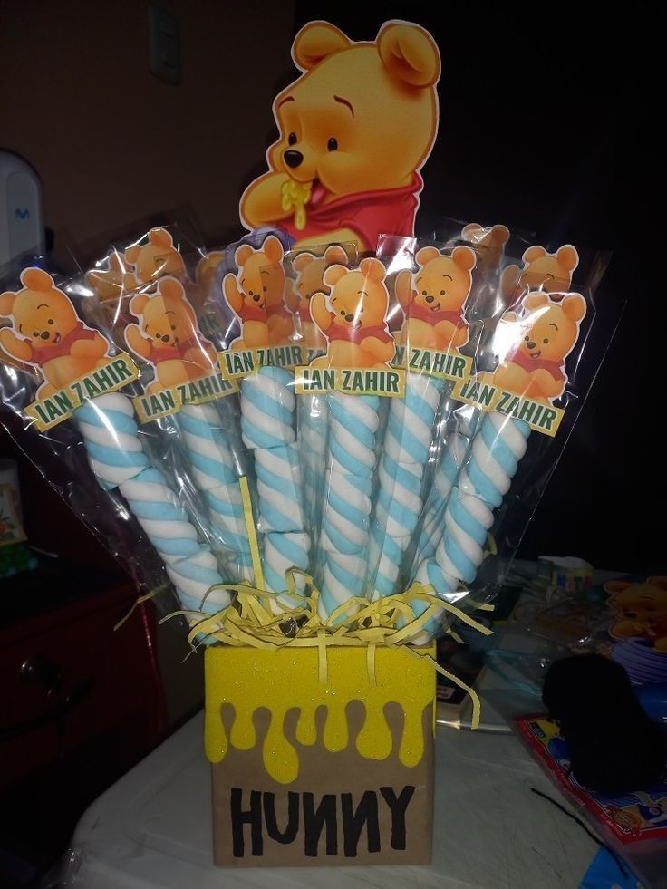 winnie the pooh birthday cake pops in a box with candy wrappers on top