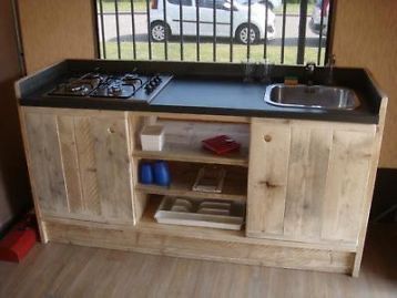 a kitchen area with a sink, stove and cabinets in the back ground next to a window