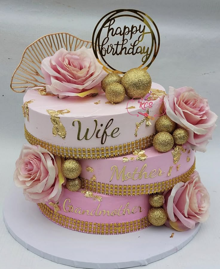 a pink and gold birthday cake with roses on top