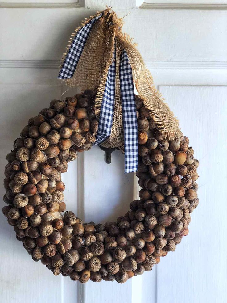 a wreath hanging on the front door with burlocks and gingham ribbon