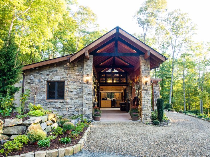 a stone building with a wooden roof surrounded by trees