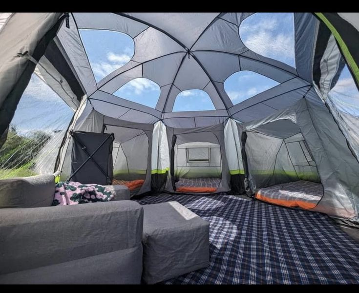 the inside of a tent with couches and pillows