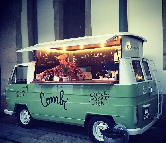 a food truck parked in front of a building with people sitting at the counter and eating