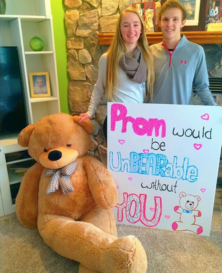 two people standing next to a large teddy bear holding a sign that says prom would be unbreakable without you