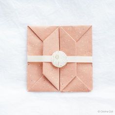 an origami envelope with a ribbon tied around the front and side, on a white background