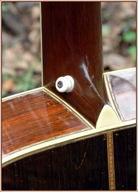 a close up view of the back end of an old fashioned wooden guitar with white knobs