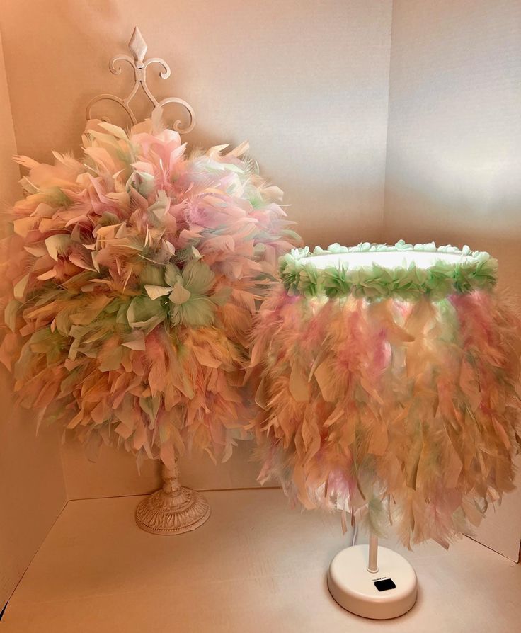 a cake decorated with feathers on top of a white table next to a vase filled with flowers