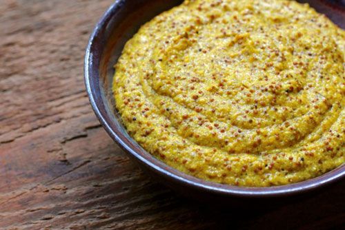 a bowl filled with yellow sauce on top of a wooden table