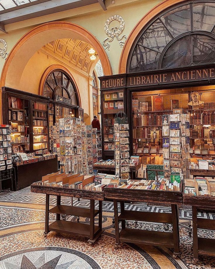 the inside of a book store with many books on tables and shelves full of books