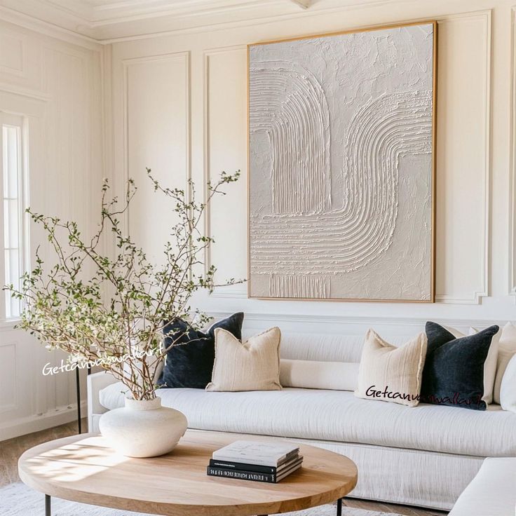 a living room filled with furniture and a large painting on the wall above it's coffee table