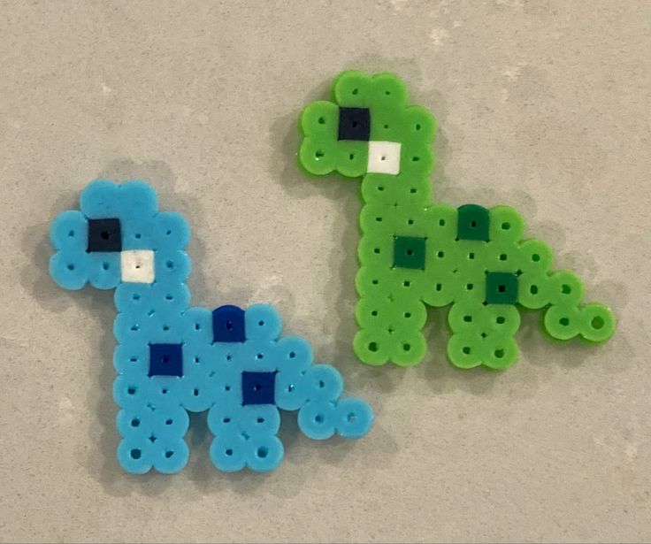 two small plastic beads sitting next to each other on top of a table, one green and the other blue