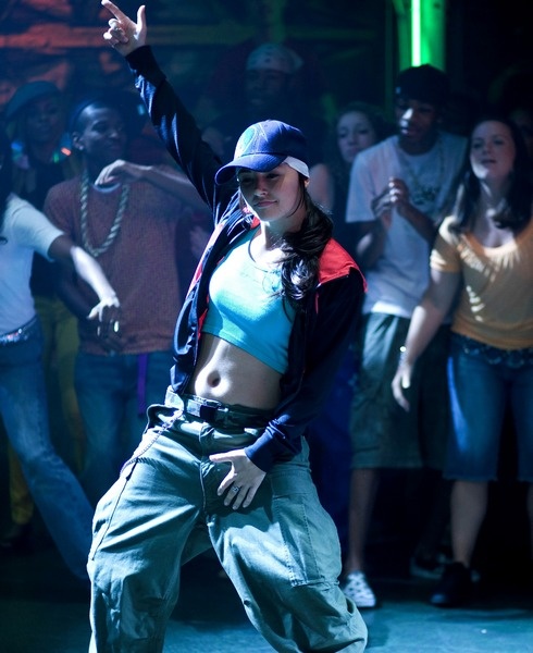 a woman is dancing in front of a crowd