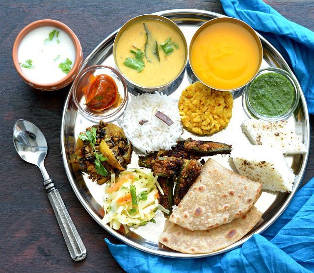 a silver plate topped with different types of food next to two bowls of sauces