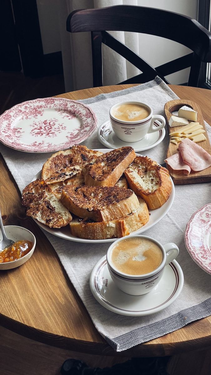 a wooden table topped with plates and bowls filled with breakfast foods on top of it