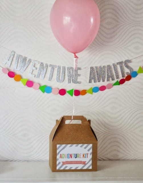 an adventure await kit in a box with a balloon and streamers on the string