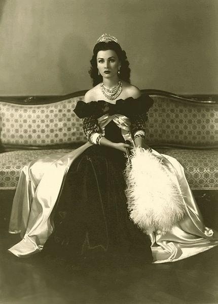 an old black and white photo of a woman sitting on a couch