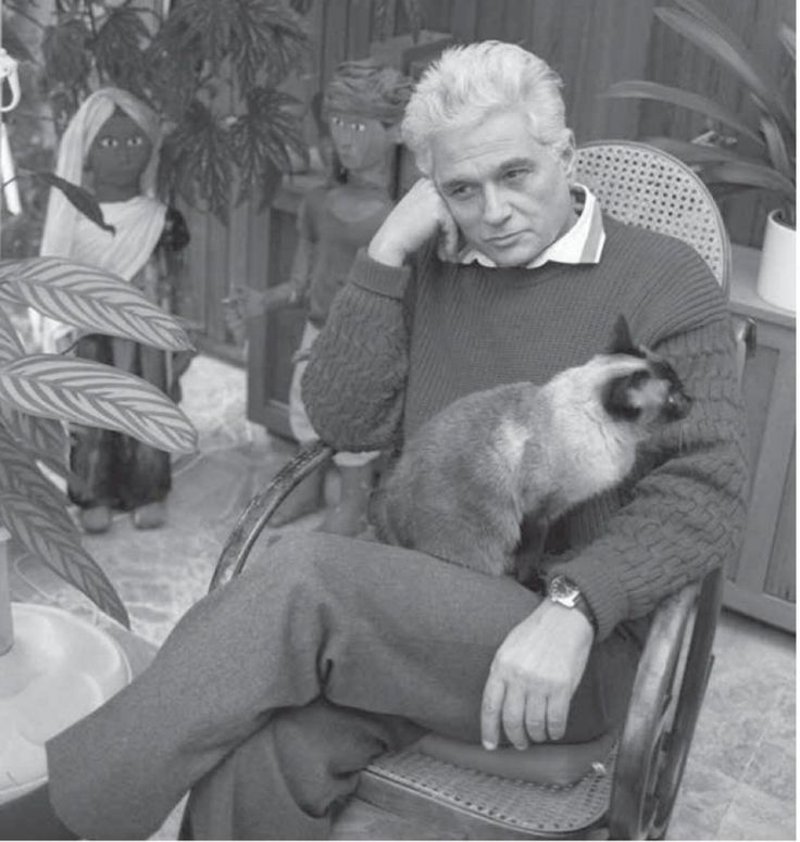 an old man sitting in a chair holding a cat