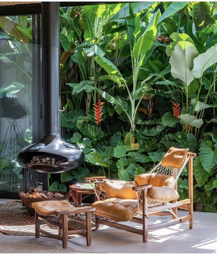 a living room with chairs and a fire place in front of a wall of plants