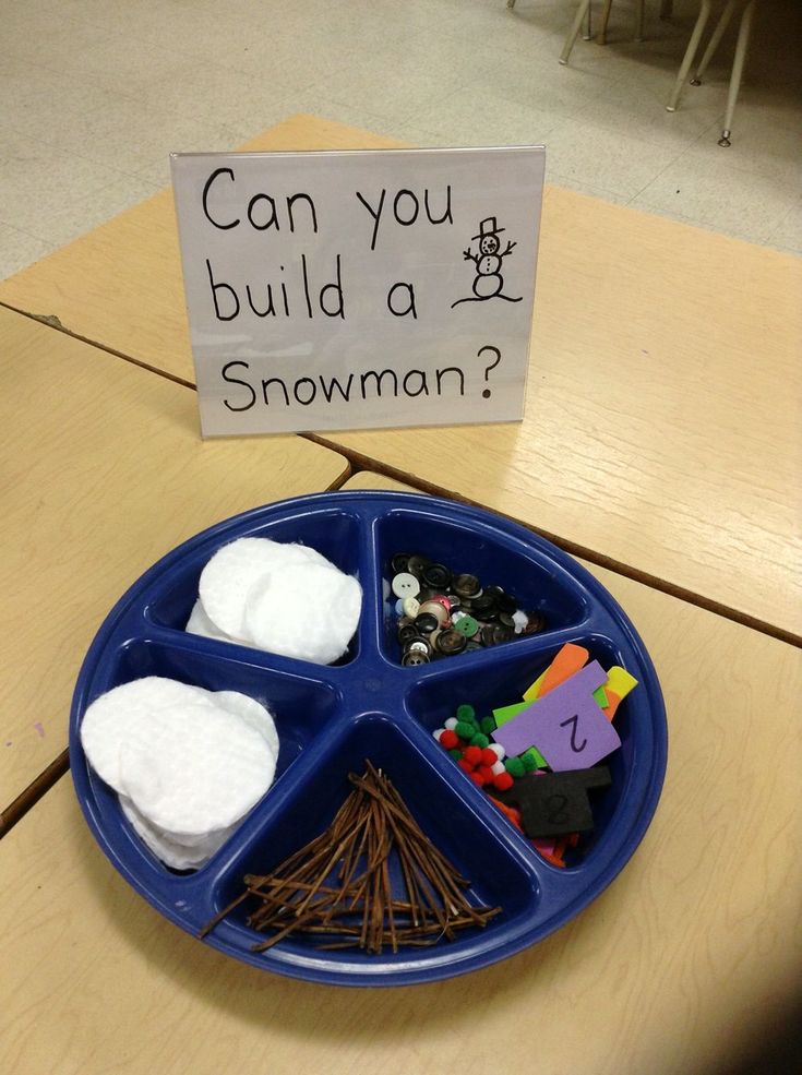 a blue plate topped with lots of food on top of a wooden table next to a sign that says can you build a snowman?