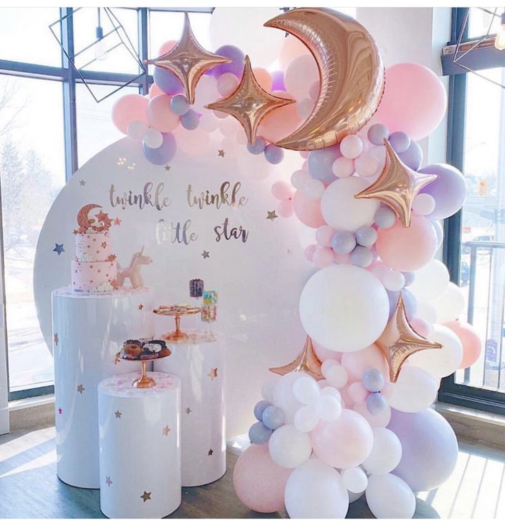 a table topped with balloons and cake next to a giant balloon arch that says twinkle the little star