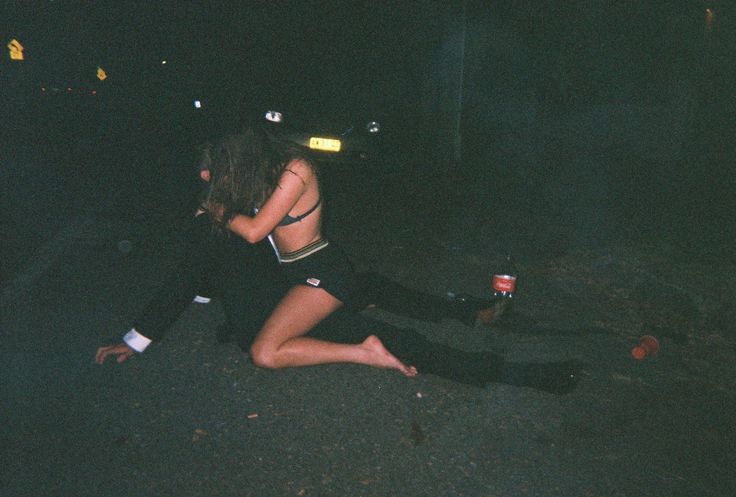 a man and woman sitting on the ground at night