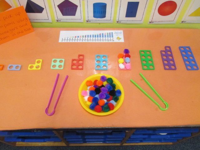 an orange table topped with lots of different colored toys and plastic pegs on top of it